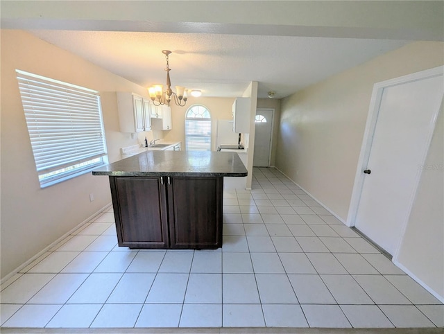 kitchen with sink, an inviting chandelier, pendant lighting, dark brown cabinets, and light tile patterned flooring