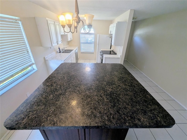 kitchen with sink, light tile patterned floors, a notable chandelier, white cabinets, and range with electric stovetop