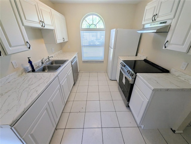 kitchen with appliances with stainless steel finishes, light tile patterned floors, white cabinetry, and sink