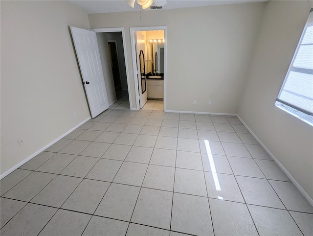 tiled empty room featuring ceiling fan