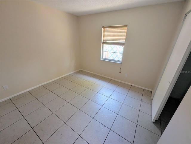 tiled spare room with a textured ceiling