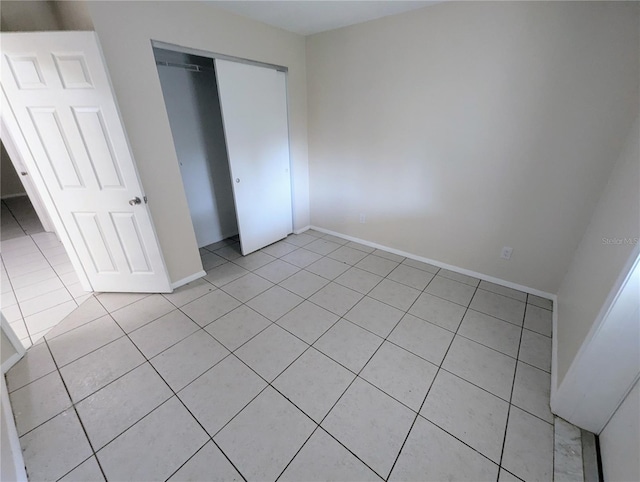 unfurnished bedroom featuring a closet and light tile patterned floors