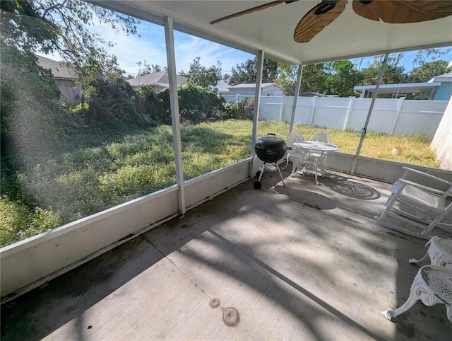 unfurnished sunroom featuring ceiling fan