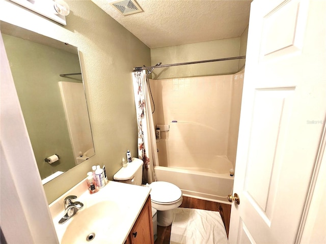 full bathroom with shower / bath combo, vanity, toilet, a textured ceiling, and wood-type flooring