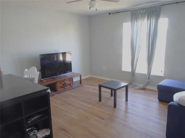 living room featuring light hardwood / wood-style flooring and ceiling fan