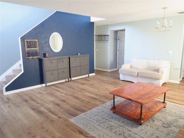 living room featuring wood-type flooring and an inviting chandelier