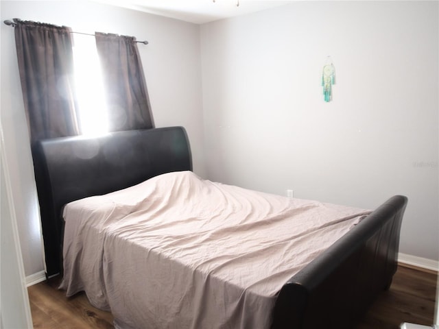 bedroom with dark hardwood / wood-style floors