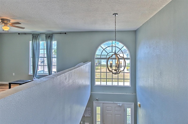 foyer with hardwood / wood-style flooring, plenty of natural light, and a textured ceiling