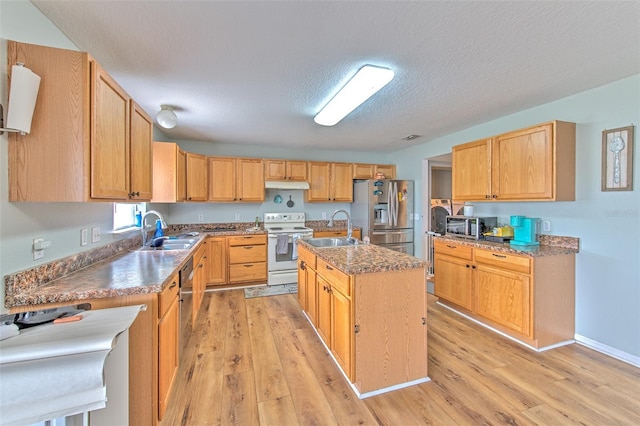 kitchen featuring stainless steel appliances, sink, a center island with sink, and light hardwood / wood-style flooring