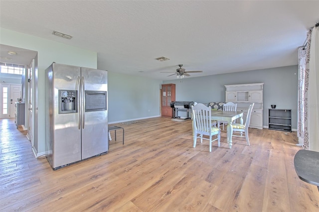 dining area featuring a textured ceiling, light hardwood / wood-style flooring, and ceiling fan