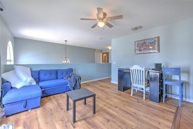 living room featuring a textured ceiling, ceiling fan, and light wood-type flooring