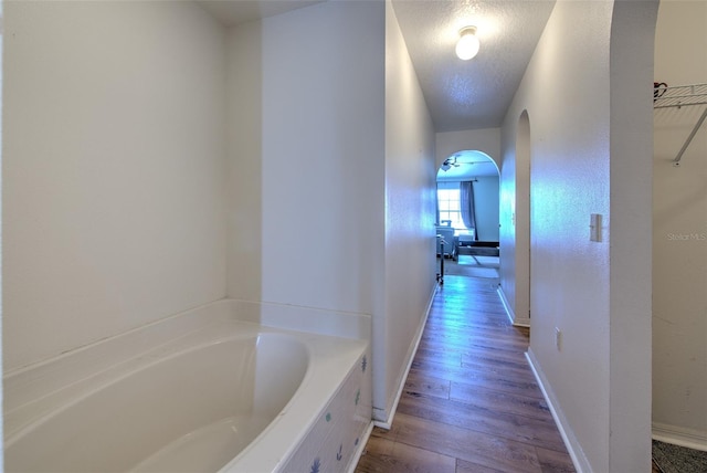 corridor featuring hardwood / wood-style floors and a textured ceiling