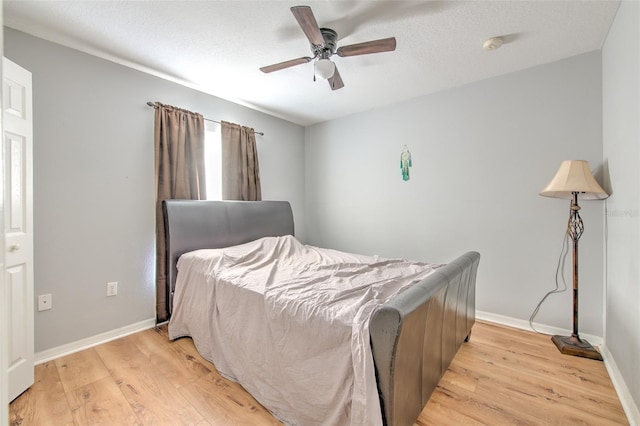 bedroom featuring a textured ceiling, ceiling fan, and light hardwood / wood-style flooring