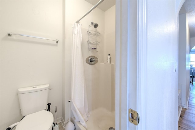 bathroom with a shower with curtain and toilet