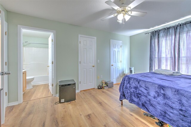 bedroom with stainless steel fridge, ceiling fan, connected bathroom, and light hardwood / wood-style floors