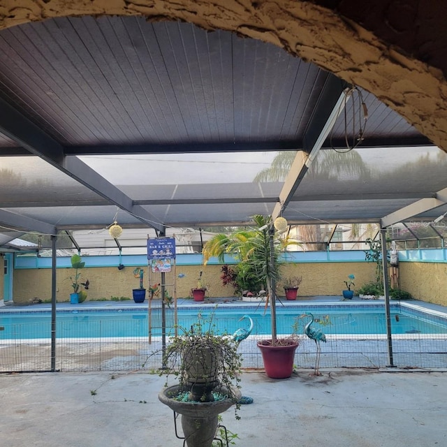 view of swimming pool featuring a patio area and glass enclosure