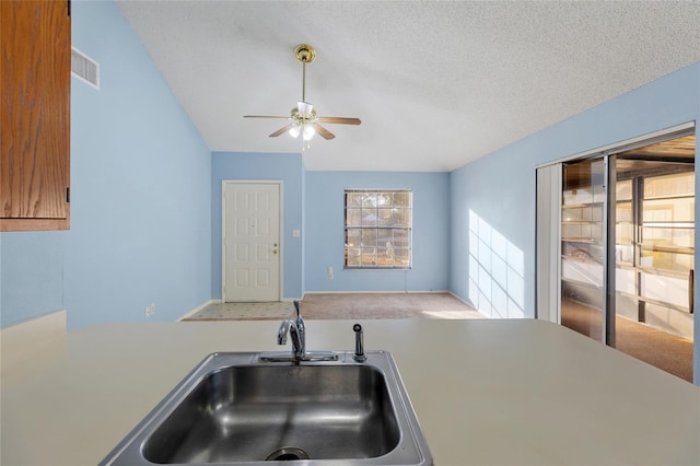 kitchen featuring a textured ceiling, ceiling fan, and sink