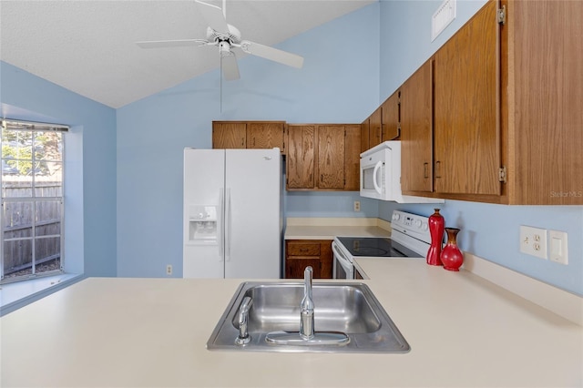 kitchen with lofted ceiling, white appliances, sink, ceiling fan, and a textured ceiling