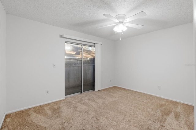 spare room with ceiling fan, light colored carpet, and a textured ceiling