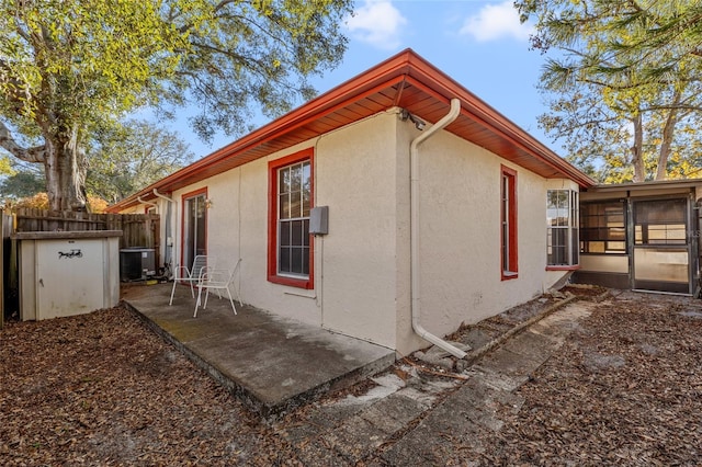 view of home's exterior featuring central air condition unit and a sunroom