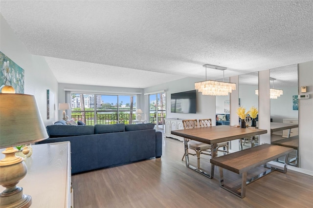 dining space with hardwood / wood-style floors, a textured ceiling, and a chandelier