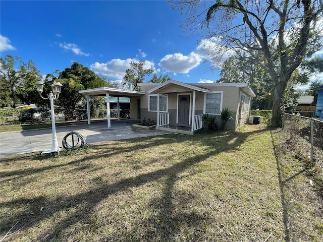 view of front facade featuring a front yard, central AC, and a carport