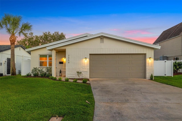 ranch-style house with a yard and a garage