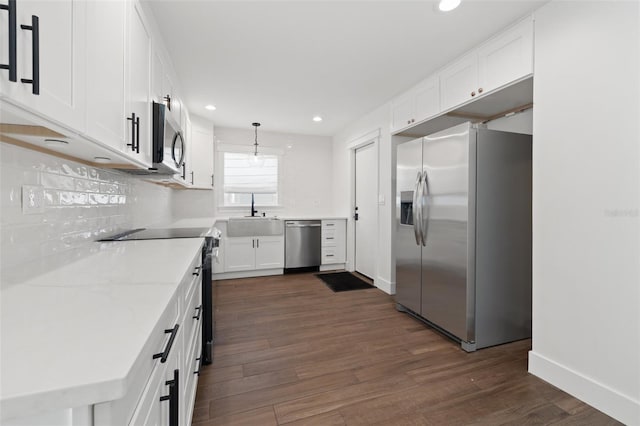 kitchen featuring pendant lighting, white cabinets, dark wood-type flooring, and appliances with stainless steel finishes