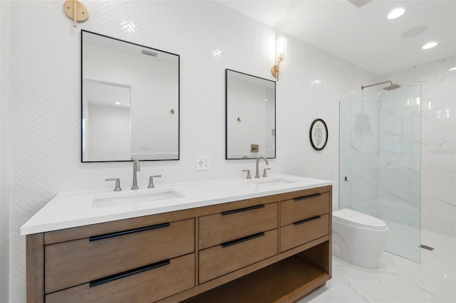 bathroom with a tile shower, vanity, and toilet