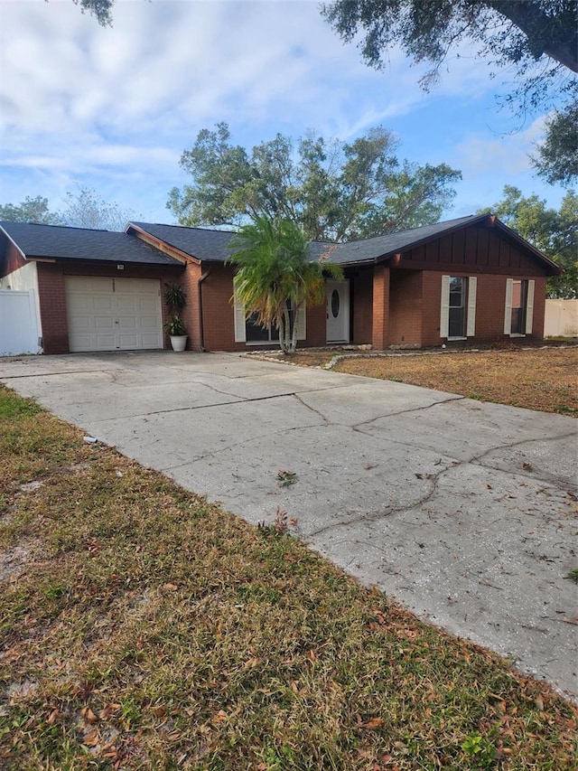 single story home featuring a front lawn and a garage