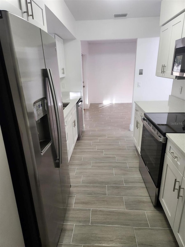 kitchen with white cabinets and appliances with stainless steel finishes