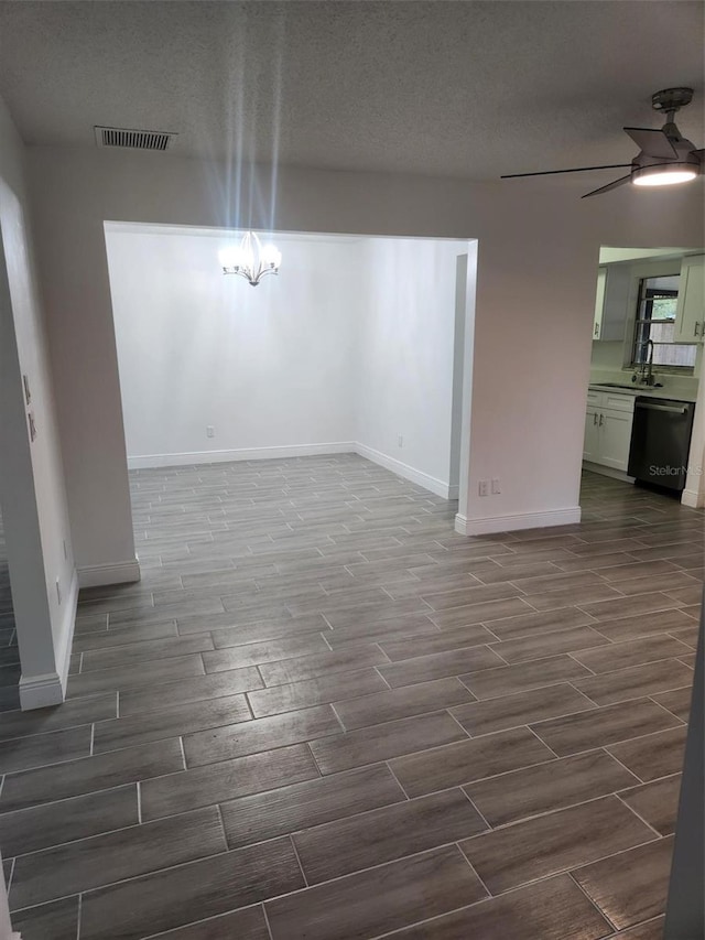 empty room with ceiling fan and a textured ceiling