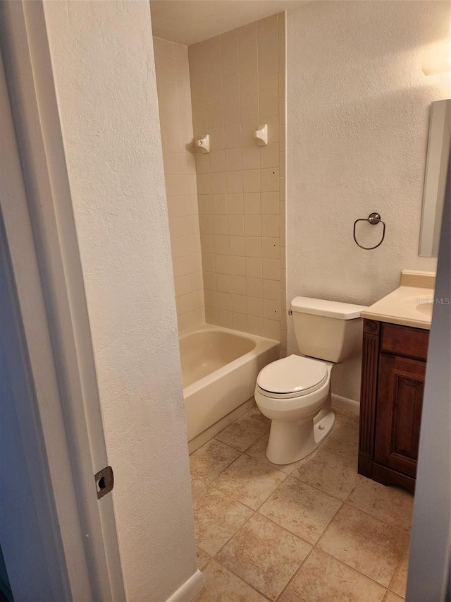 full bathroom with tiled shower / bath, vanity, and toilet