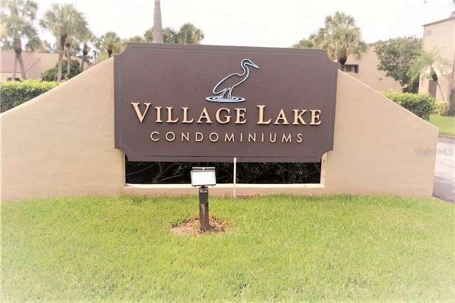 community / neighborhood sign featuring a lawn