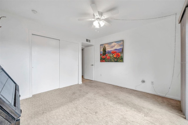 unfurnished bedroom with ceiling fan, a closet, and light colored carpet