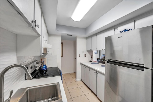 kitchen with decorative backsplash, appliances with stainless steel finishes, sink, light tile patterned floors, and white cabinets