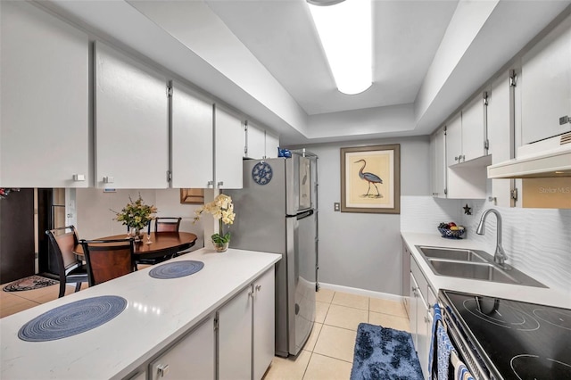 kitchen featuring white cabinetry, sink, light tile patterned floors, and stove