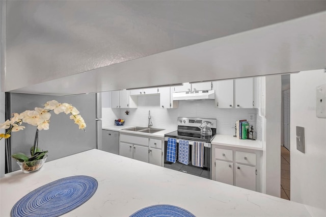 kitchen featuring decorative backsplash, tile patterned floors, stainless steel appliances, sink, and white cabinetry