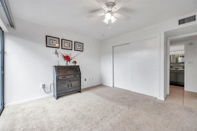 interior space featuring carpet, a closet, and ceiling fan