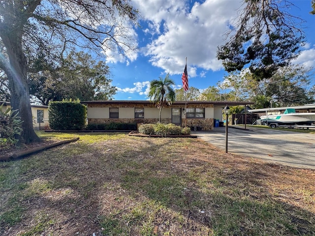 ranch-style house featuring a carport and a front lawn