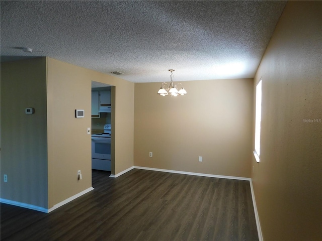 empty room featuring a textured ceiling, dark hardwood / wood-style floors, and an inviting chandelier