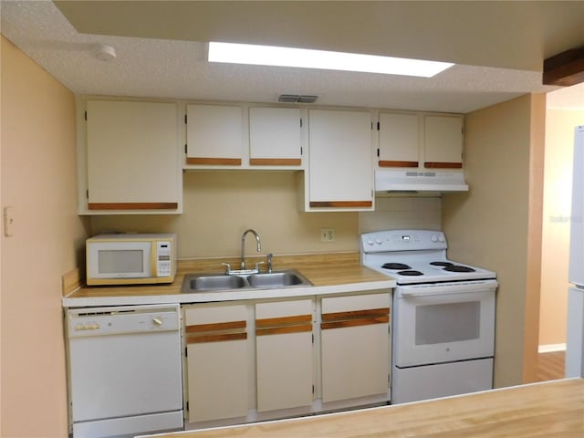 kitchen featuring a textured ceiling, white appliances, and sink