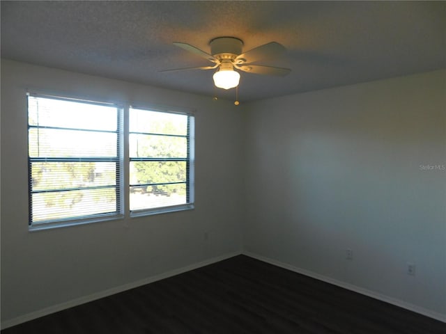 empty room featuring dark wood-type flooring and a wealth of natural light