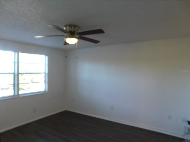 spare room with ceiling fan and dark wood-type flooring