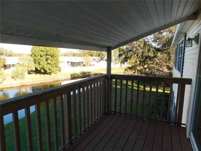 wooden deck with a lawn and a water view