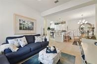 living room featuring beam ceiling and a chandelier