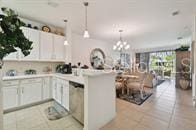 kitchen featuring white cabinets, decorative light fixtures, kitchen peninsula, and light tile patterned floors