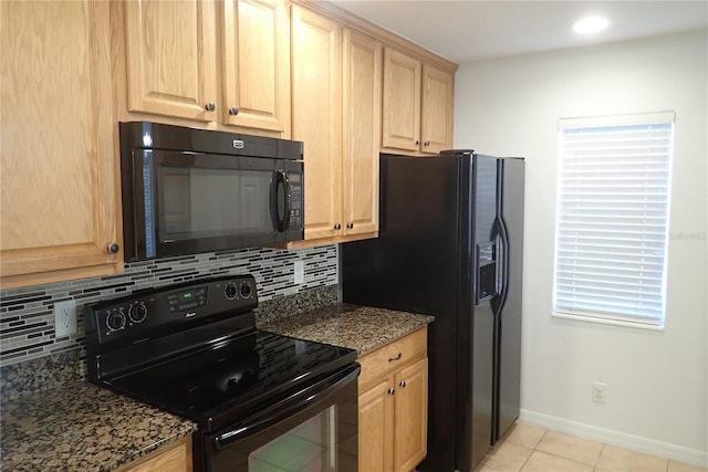 kitchen featuring black appliances, light tile patterned flooring, dark stone countertops, and backsplash