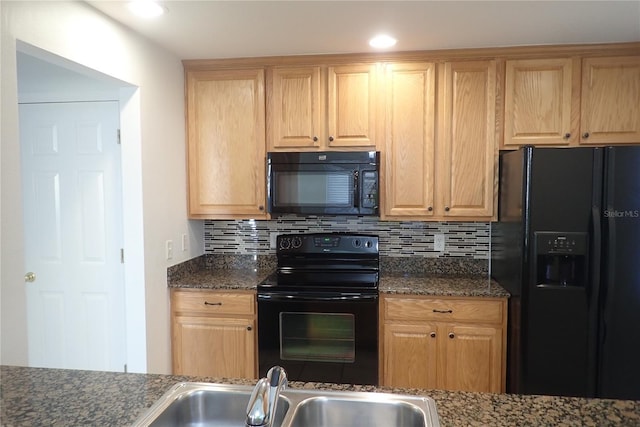 kitchen featuring sink, tasteful backsplash, dark stone counters, and black appliances