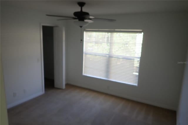 carpeted empty room featuring ceiling fan